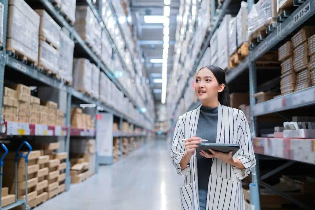 Woman checking inventory of retail store in warehouse