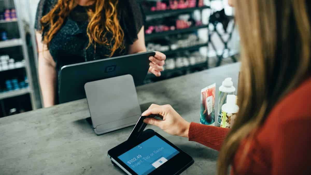 A customer and counter staff at a retail store using digital technology