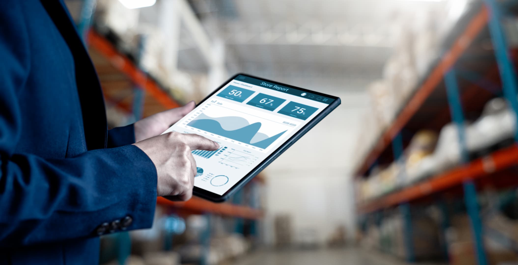 Close-up of business person in warehouse using tablet with ERP software dashboard to monitor inventory levels, sales performance, and analytics for optimized supply chain management