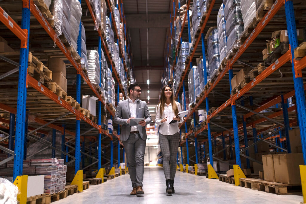 Warehouse Managers Walking Through Large Distribution Center Scaled 1